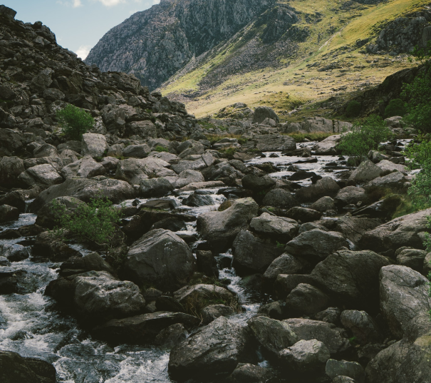 Volcanic boulders in a stream in mountainous terrain